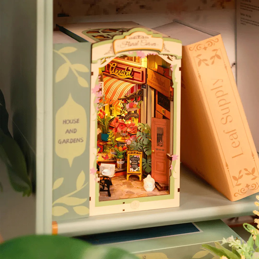 Book Nook Floral Corner intégré dans une bibliothèque entre des livres de jardinage.