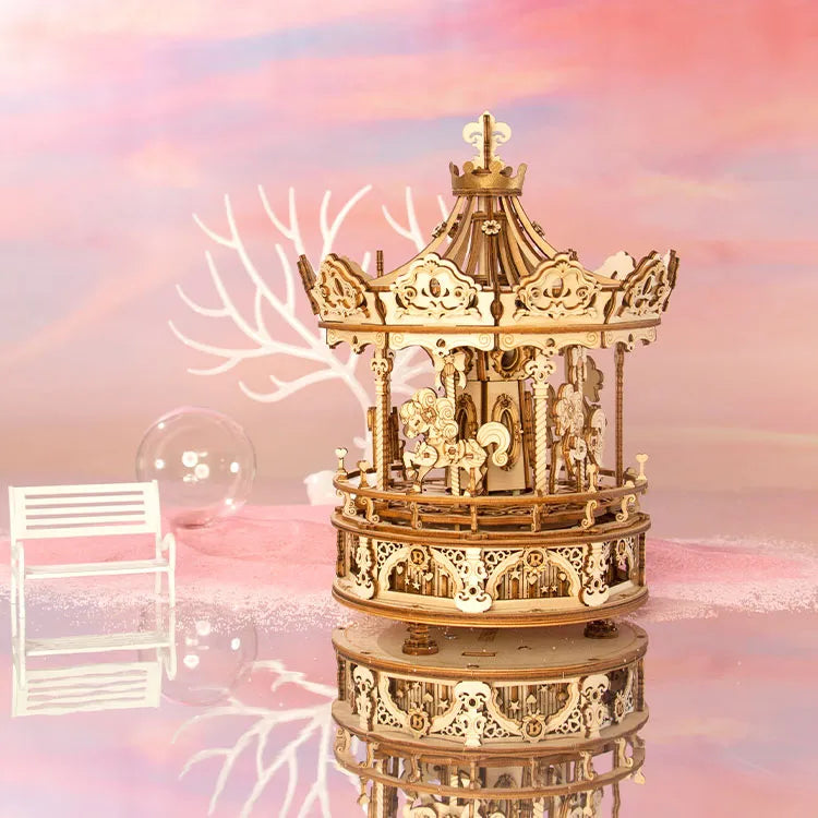 Puzzle 3D Carrousel Romantique assemblé avec ses décorations victoriennes et sa finition bois naturel sur fond rose.